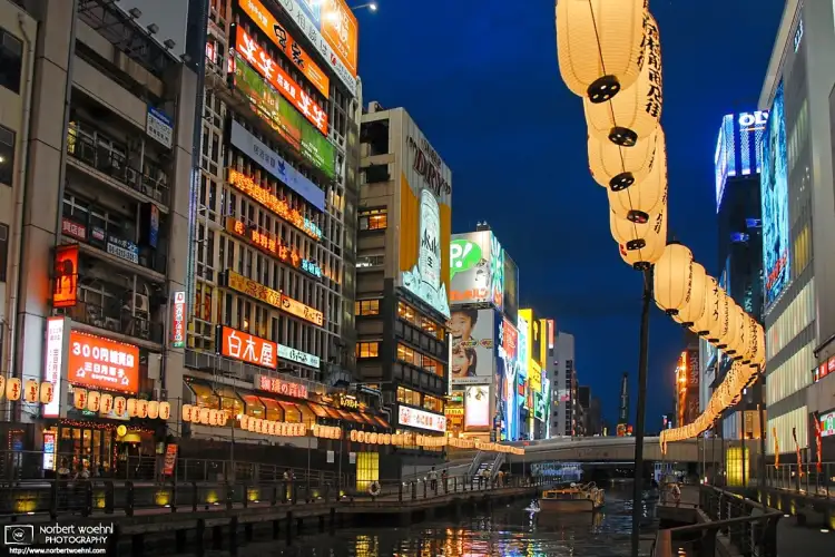 An evening perspective along the Dōtonbori Canal in Osaka, Japan. Historically a theater district, Dotonbori is now a popular nightlife and entertainment area.