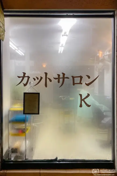 View through the fogged window of Cut Salon K, a local hairdresser shop in the Itabashi Ward of Tokyo, Japan.