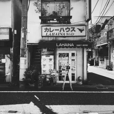 High-contrast monochrome photograph of Curry House Lahaina, a small restaurant in the Azusawa neighborhood of Itabashi Ward in Tokyo, Japan.
