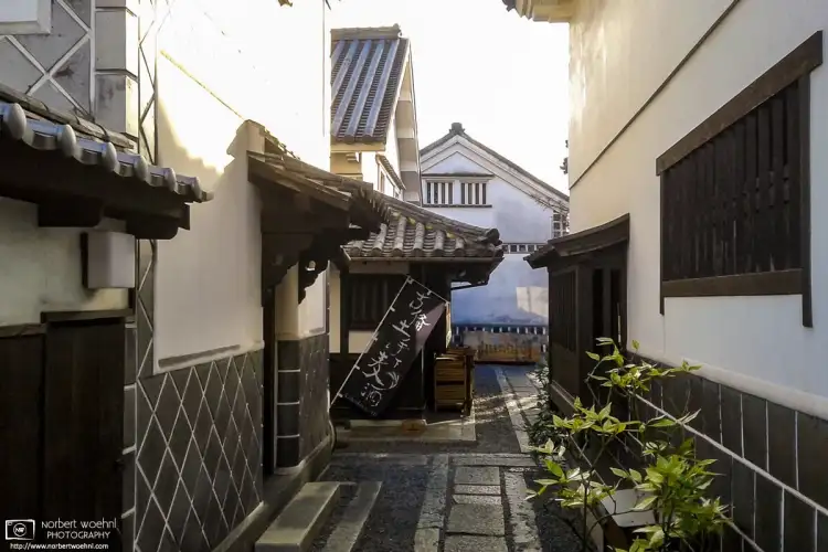 A glimpse between some of the beautiful old warehouse buildings in the Bikan District of Kurashiki, Japan.