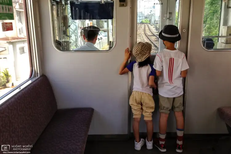 Kids enjoying the drivers perspective while riding a Kintetsu Line train in Kyoto, Japan.