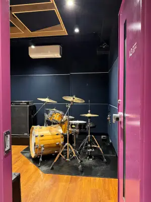 Looking through the door of my drum practice room. The kit looks set up and ready to be played.