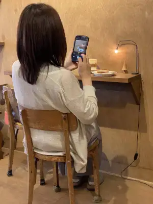 A customer taking the obligatory food photo for sharing on social media, at Small Things Coffee in Sapporo, Japan.
