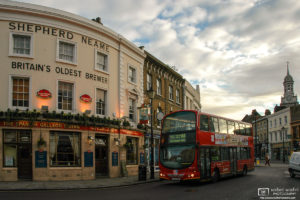 A double-decker bus is passing the Spanish Galleon Tavern, a historic 19th century pub near Cutty Sark in Greenwich, London.