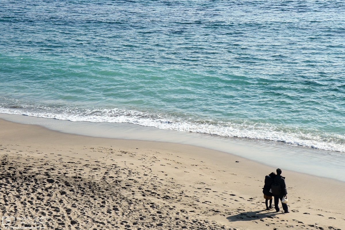 A contemplative seaside moment on the beach close to Kamakurakokomae Station in Kamakura, Japan.
