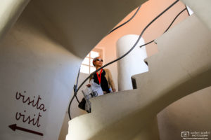 A visitor walking a spiral staircase inside Casa Batlló, Antoni Gaudí's architectural masterpiece in Barcelona, Spain.