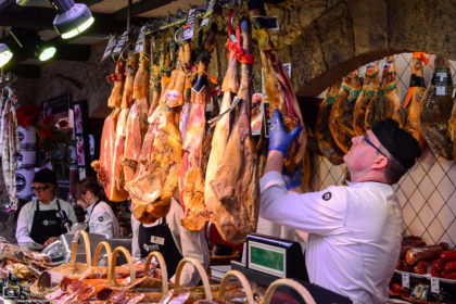 Jambon ham and other assorted meats at this shop inside Mercat de la Boqueria in Barcelona, Spain.