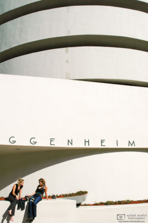 Two women chatting outside the Solomon R. Guggenheim Museum in New York City, USA.