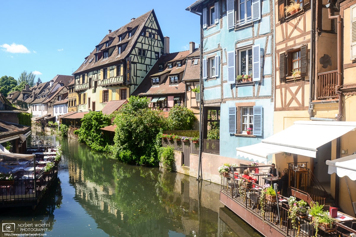 Restaurants and half-timbered buildings along the Lauch River in the historic center of Colmar, France.
