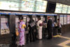At Kyoto Station in Japan, kimono-clad women are buying train tickets at ticket machines.