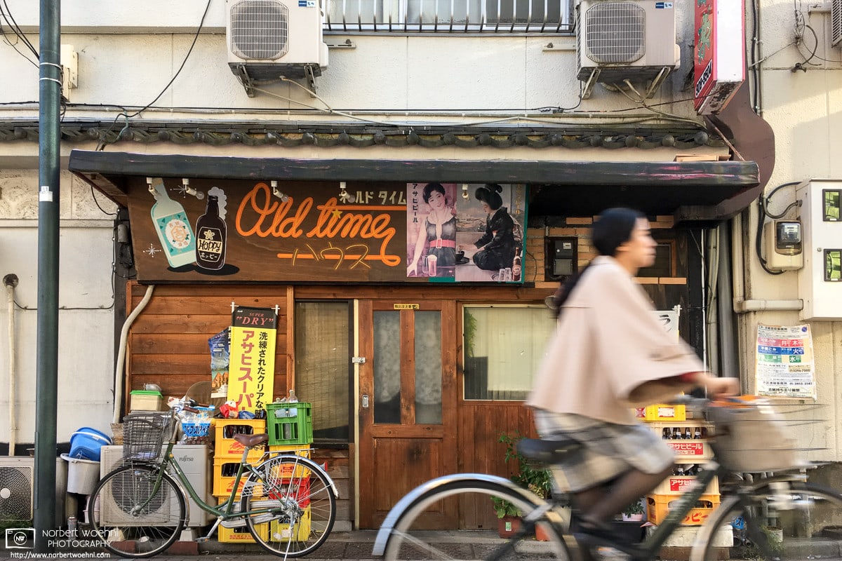 A bicyclist is passing in front of an old restaurant in the Kita Ward of Tokyo, Japan.