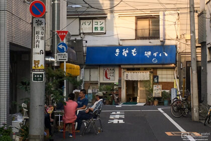 Locals having a casual chat on a hot summer evening in the Taito ward of Tokyo, Japan.